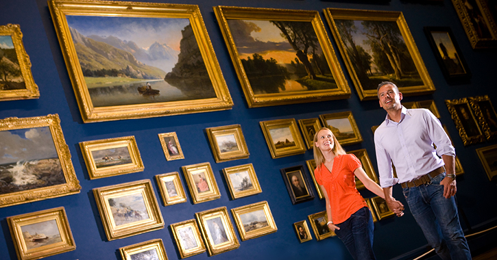 Man and woman walking through picture gallery inside the Bowes Museum